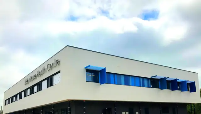 Health centre elevation with blue brise soleil louvres above a band of aluminium windows