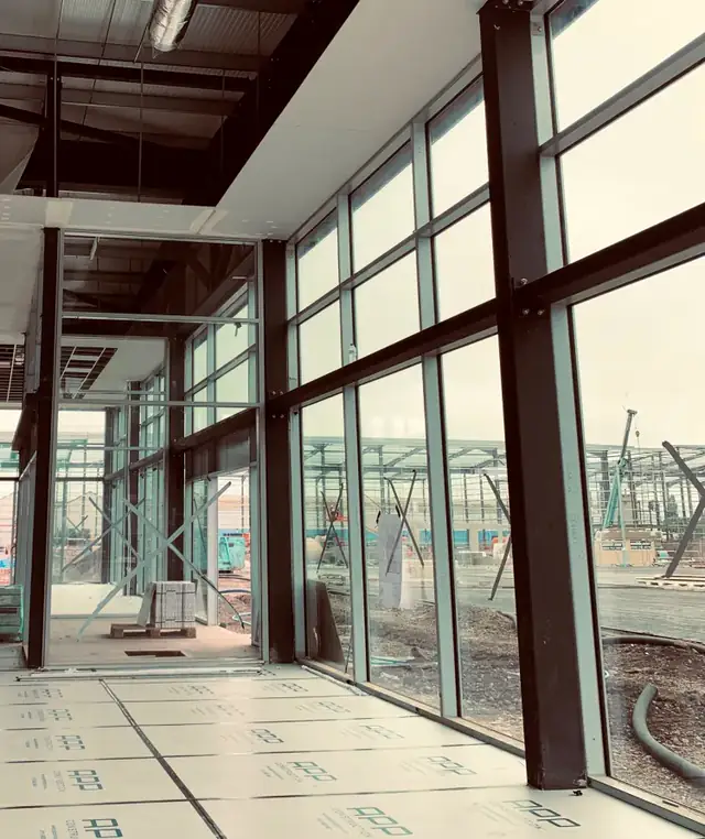 Interior view of full height showroom glazing with the bronze mullions running floor to ceiling