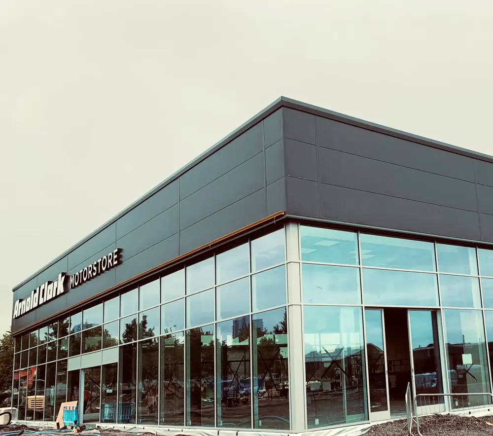 Arnold Clark Motorstore in Wolverhampton with a bronze aluminium glazed frontage wrapping the corner of the showroom